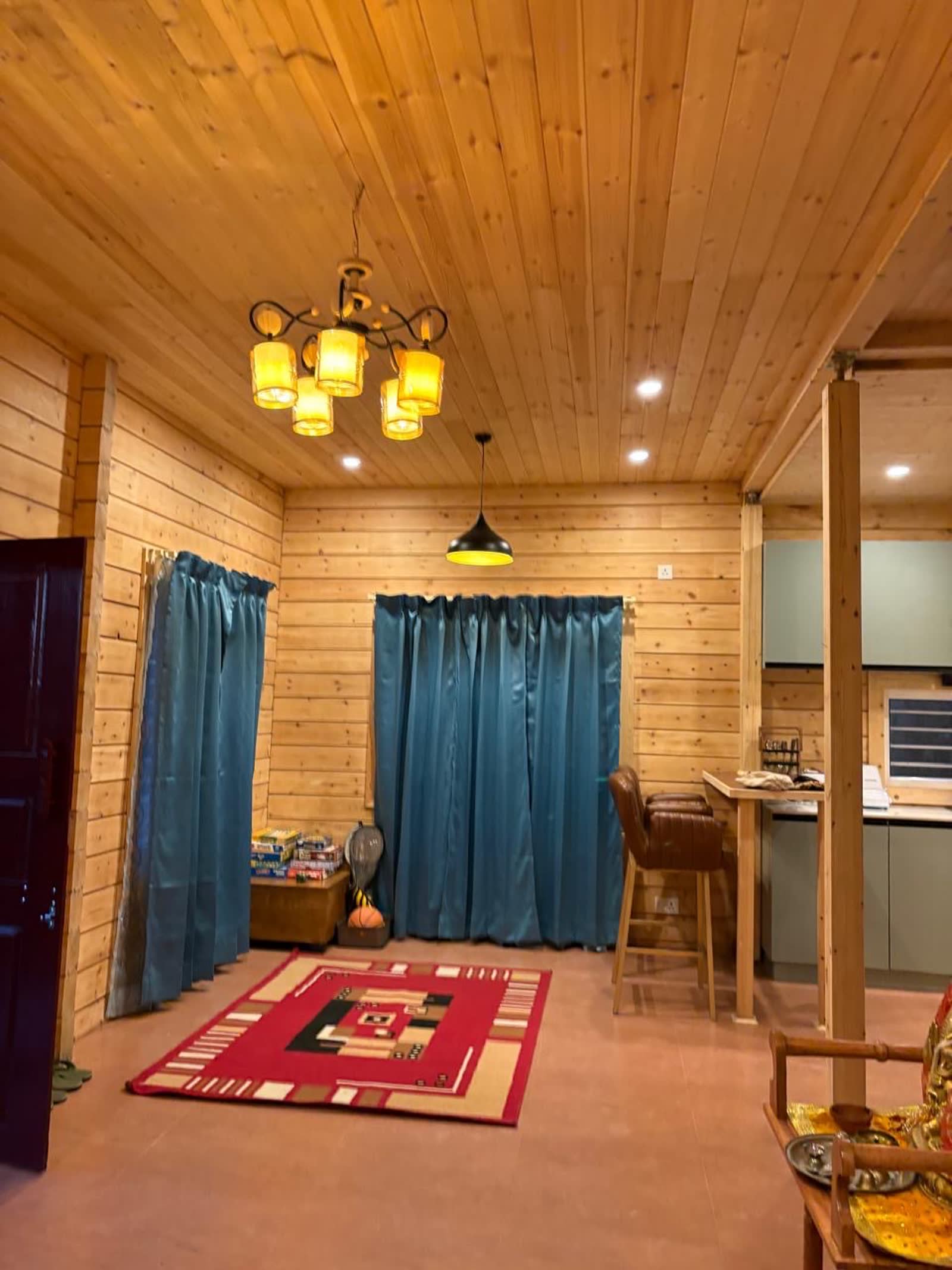 Dining area with warm chandelier light and pine wood walls